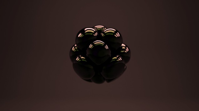 Image of a group of dark spheres balled together against a dark background